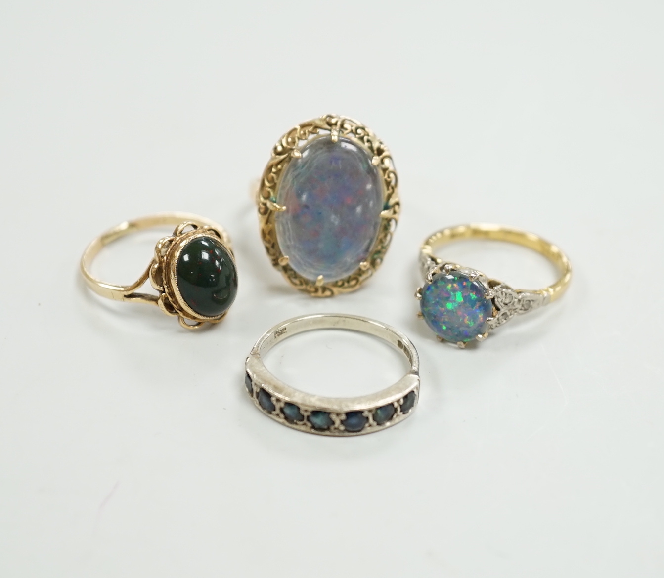 A 1940's 18ct and black opal doublet set dress ring, with diamond chip set shoulders, size L, a 14c and oval doublet ring and two other 9ct and gem set rings.